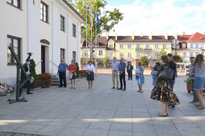 Grupa osób przed budynkiem muzeum podczas finiszu wystawy