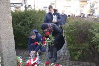 Grupa pracowników muzeum przed pomnikiem