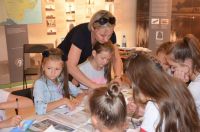 Grupa dzieci na sali w muzeum z opiekunką