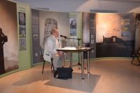 Prelegent w sali muzeum podczas przemówienia