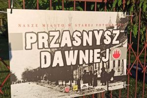 fotografia przedstawiająca widok ulicy w Przasnyszu, plansza na ogrodzeniu