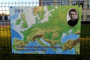plansza tytułowa wystawy z fragmentem mapy świata oraz fotografią Marii Skłodowskiej-Curie