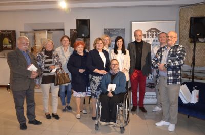 Grupa kilku osób stojących na sali wystawowej