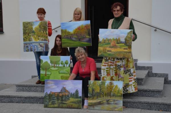 grupa osób przed budynkiem muzeum z obrazami w dłoniach