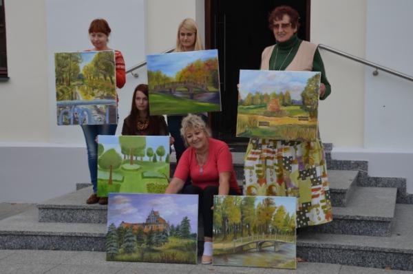 grupa osób przed budynkiem muzeum z obrazami w dłoniach