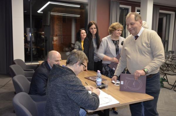 osoby stojące z książkami